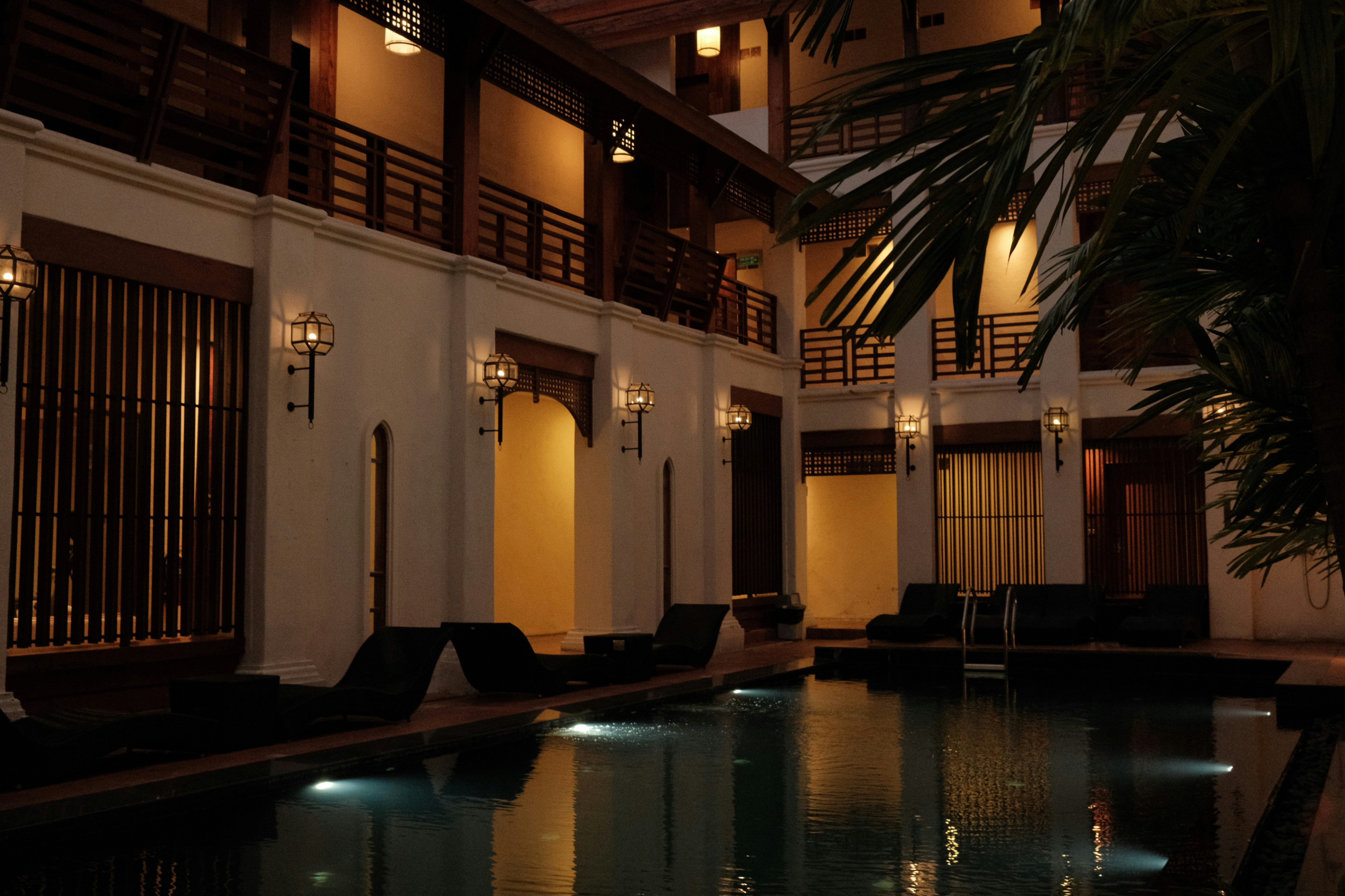 a pool in a hotel with lights on at night, 
