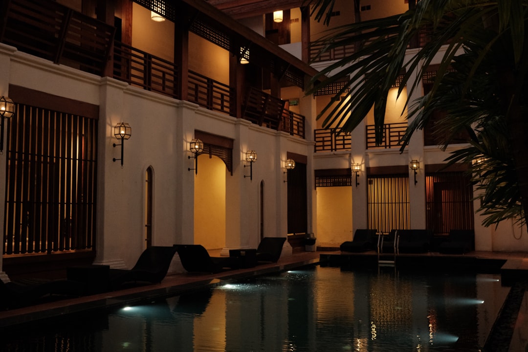 a pool in a hotel with lights on at night,