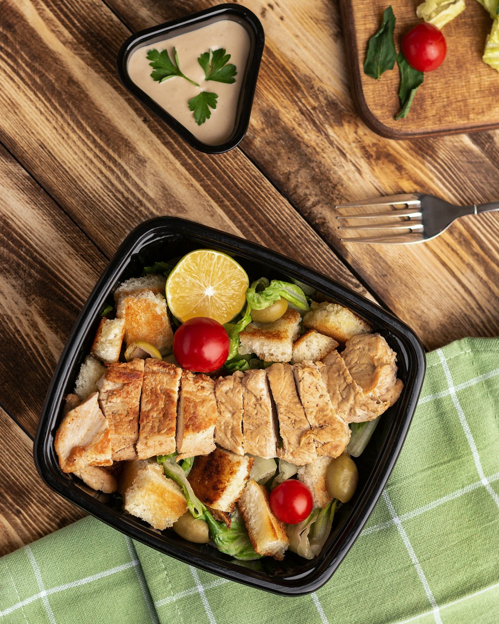 a salad with chicken, tomatoes, lettuce and cucumbers