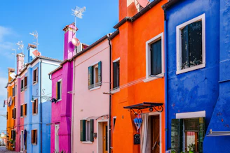 Exterior view of a freshly painted colorful house under a bright blue sky.