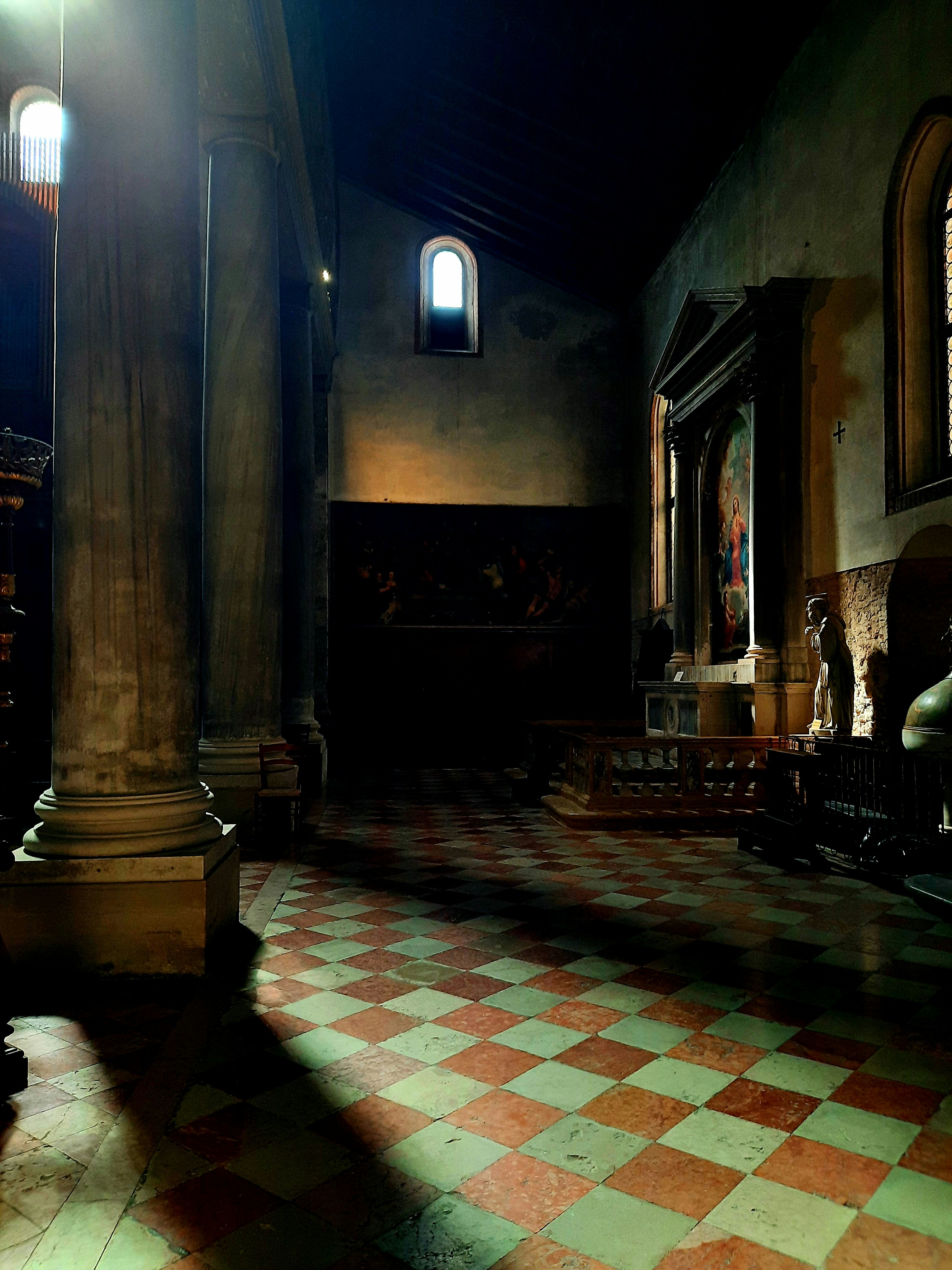 a large room with a checkered floor and columns