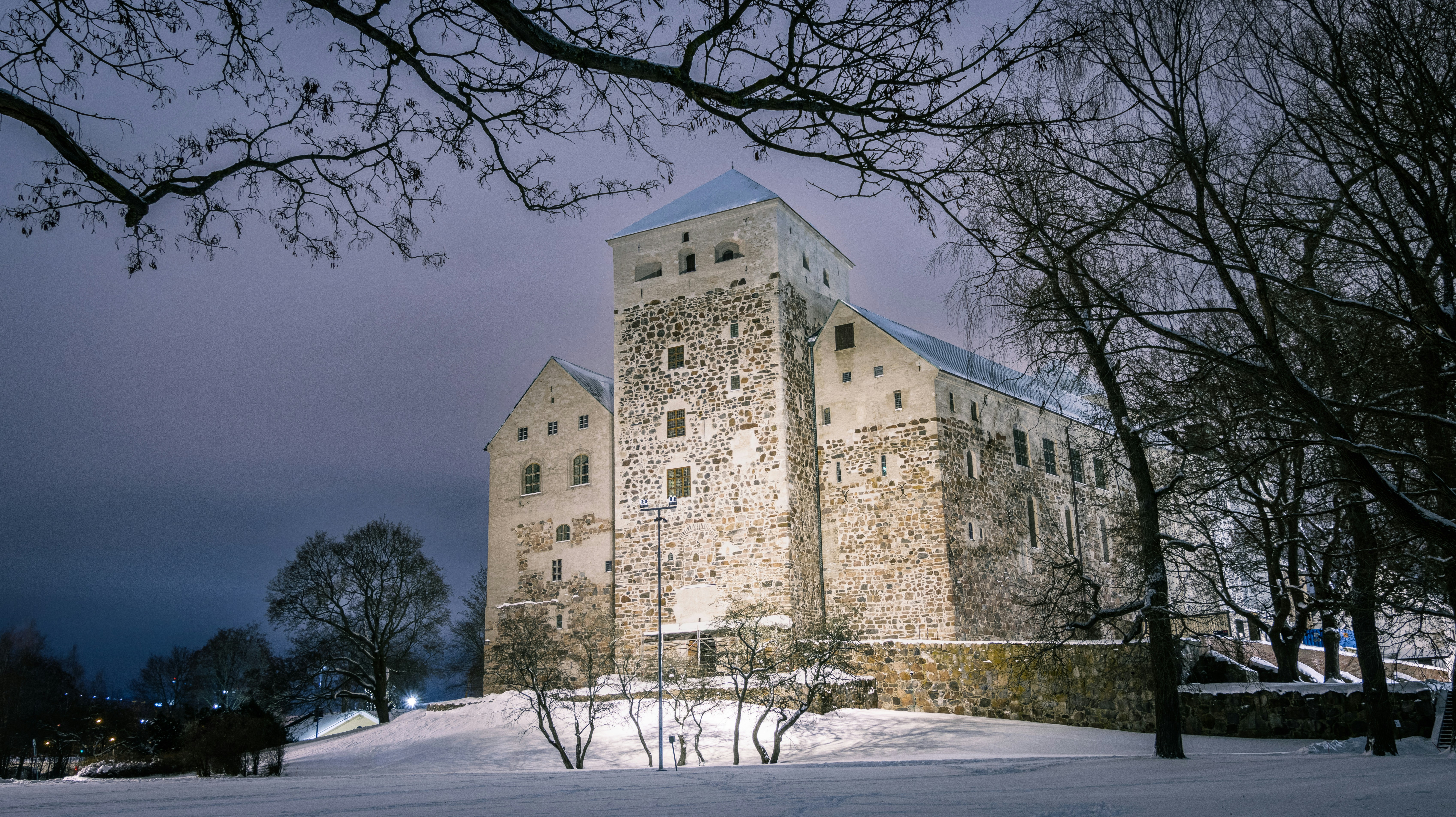 a large stone building sitting on top of a snow covered hill