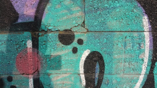 A group of teenagers creating colorful graffiti art on a wall.