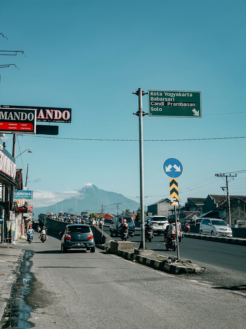 a city street with cars and people on the side of the road