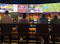 Friends cheering in front of a big screen showing a hockey game inside the cozy sports bar.