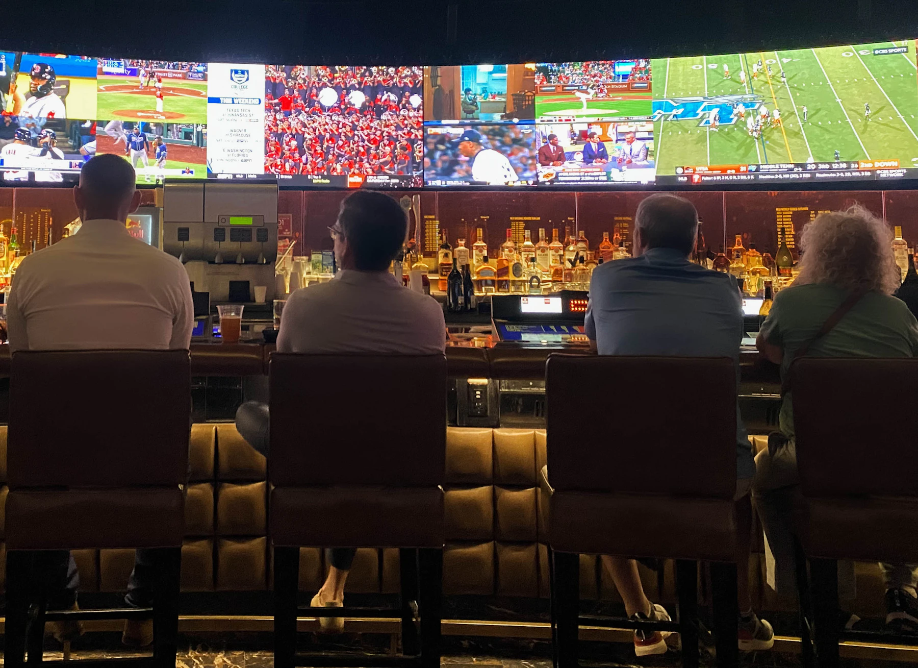 A group of people at a bar watching sports on TV