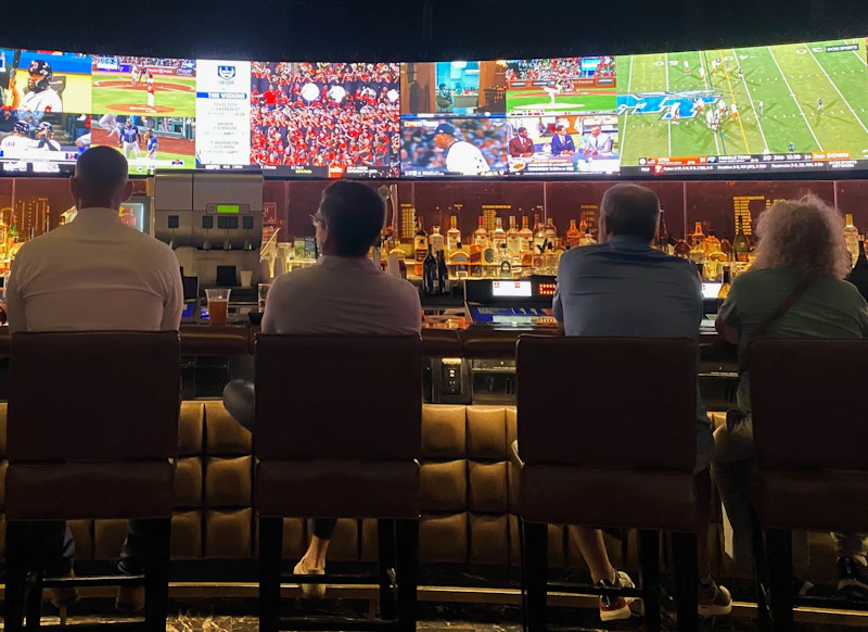 A group of people at a bar watching sports on TV