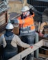 Workers wearing protective helmets and jackets on a construction site.