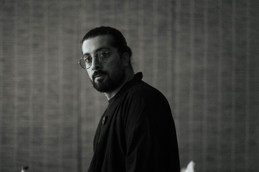 a black and white photo of a man with glasses