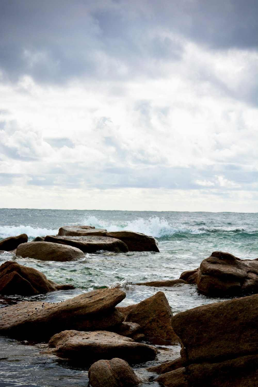 a person standing on rocks near the ocean