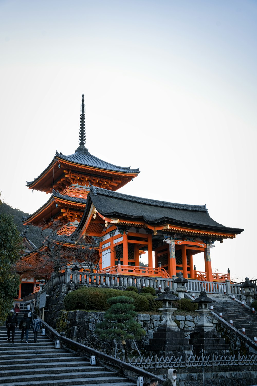 a tall building sitting on top of a lush green hillside