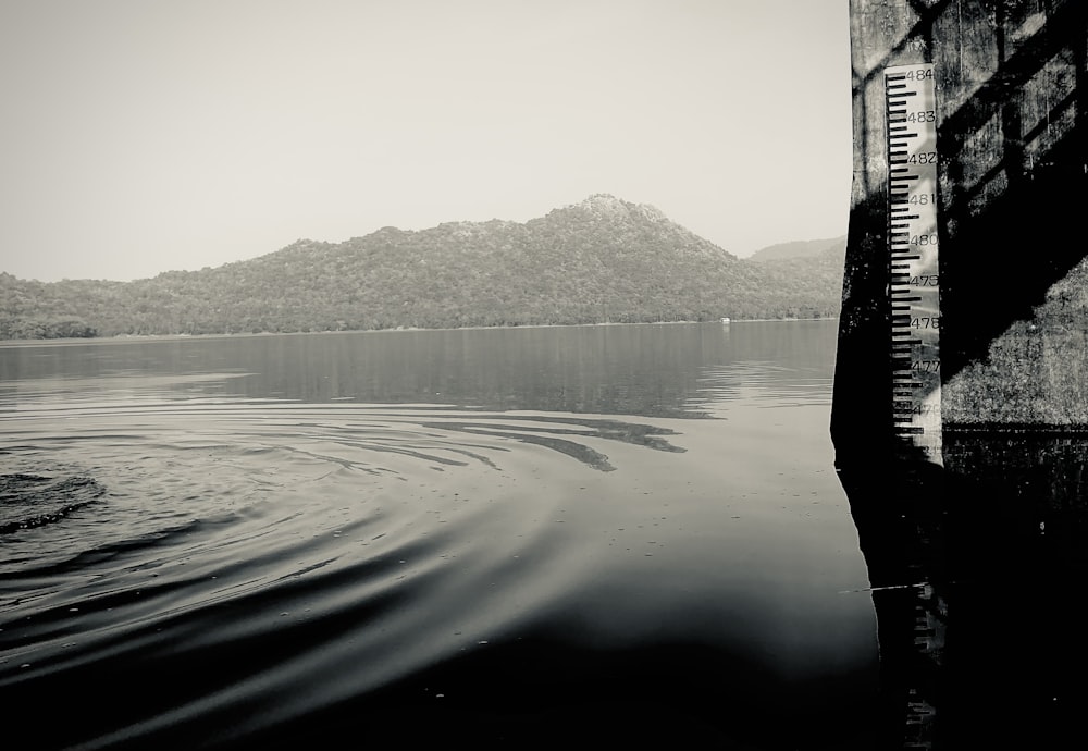 a black and white photo of a lake with mountains in the background