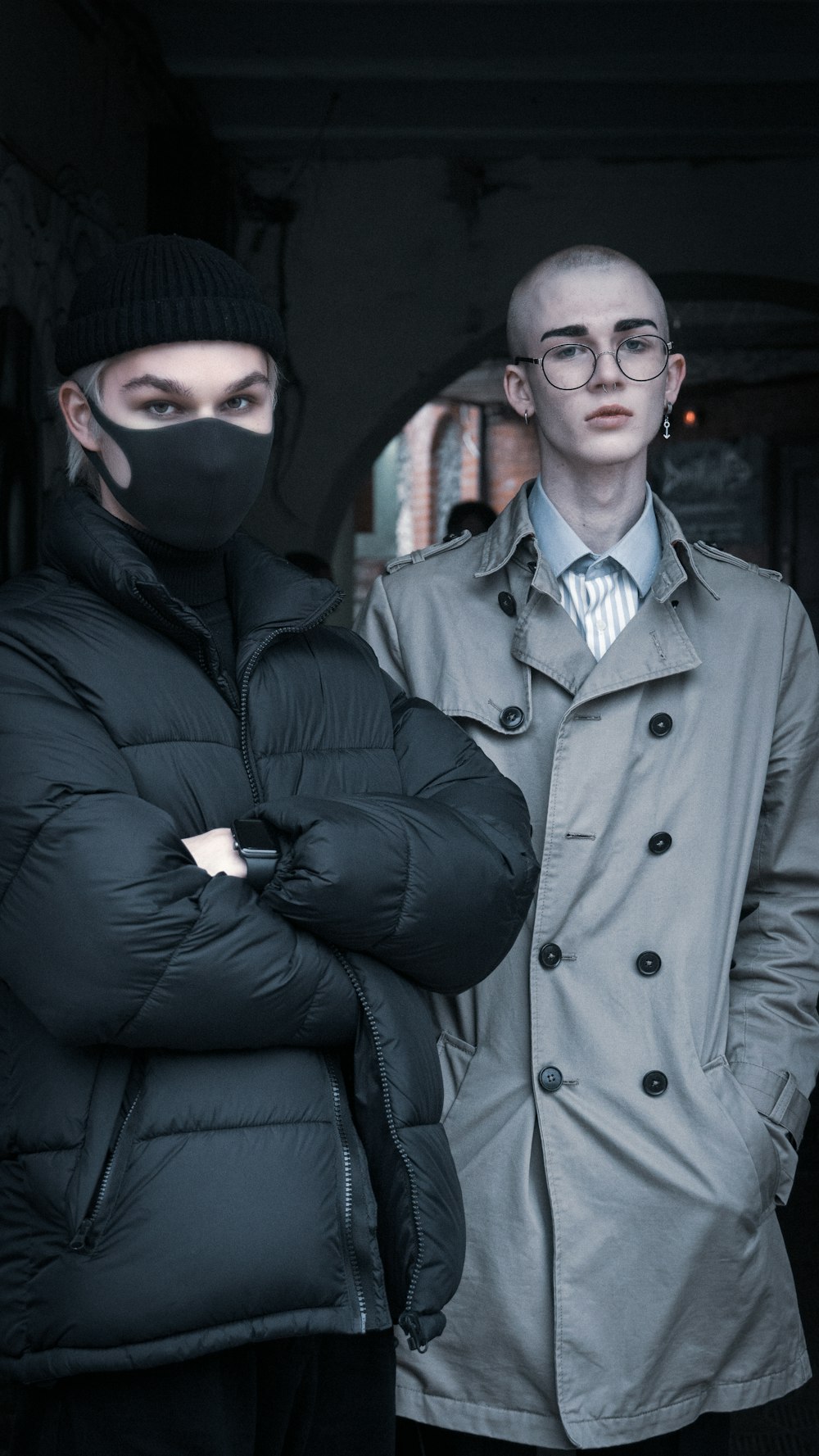 two men standing next to each other wearing masks