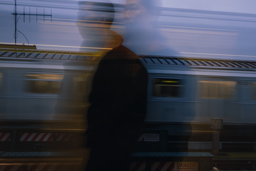 a blurry photo of a man standing in front of a train