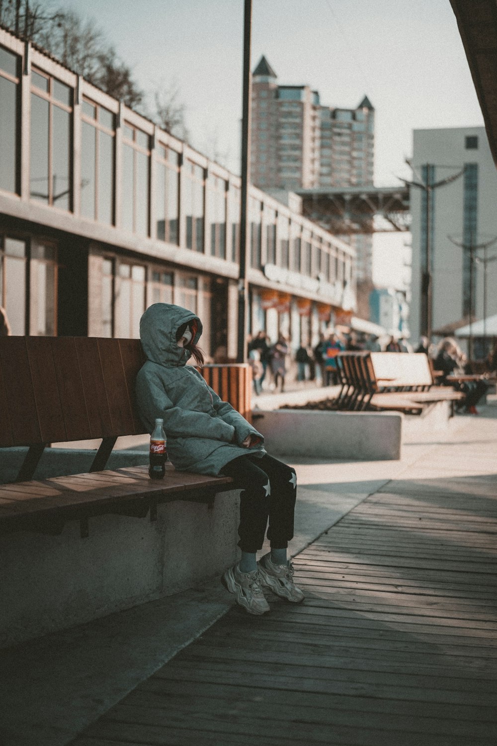 a person sitting on a bench in a city