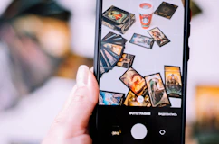a person holding up a cell phone with pictures on it