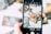 A hand is holding a smartphone, capturing an image of several tarot cards spread out in a scattered manner. The cards feature intricate and colorful designs, with various mystical and fantastical elements. The background is blurred, emphasizing the phone screen and the cards being displayed.