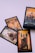 A set of tarot cards is laid out on a light surface. The cards feature illustrated designs with rich colors and intricate details. They depict various figures and symbols, including a person steering a ship, an angelic figure with wings, and a figure holding a disc, suggesting roles or personalities.