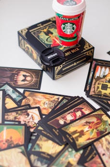 a cup of coffee sitting on top of a pile of cards