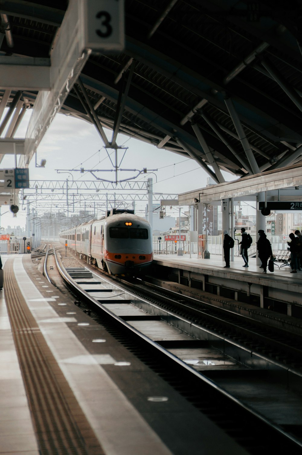 a train pulling into a train station next to a platform