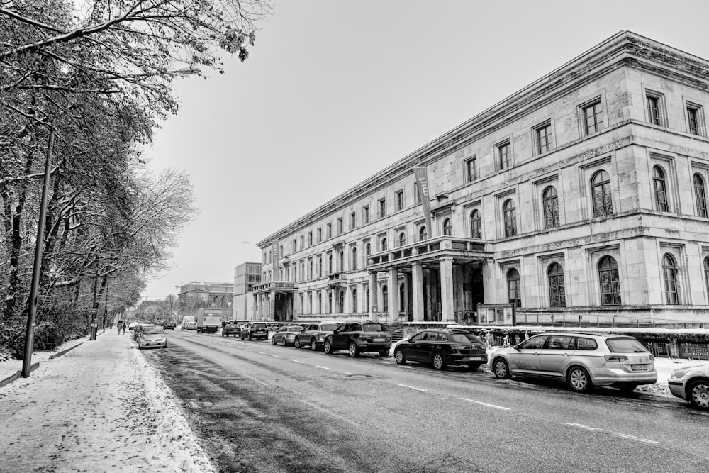 a black and white photo of cars parked in front of a building