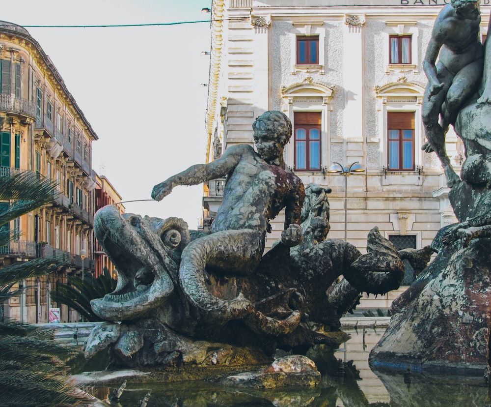 a statue of a boy riding a horse in a fountain