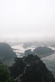 Steps leading up to a hilltop temple overlooking a misty valley.
