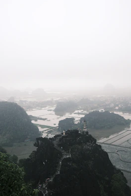 Steps leading up to a hilltop temple overlooking a misty valley.