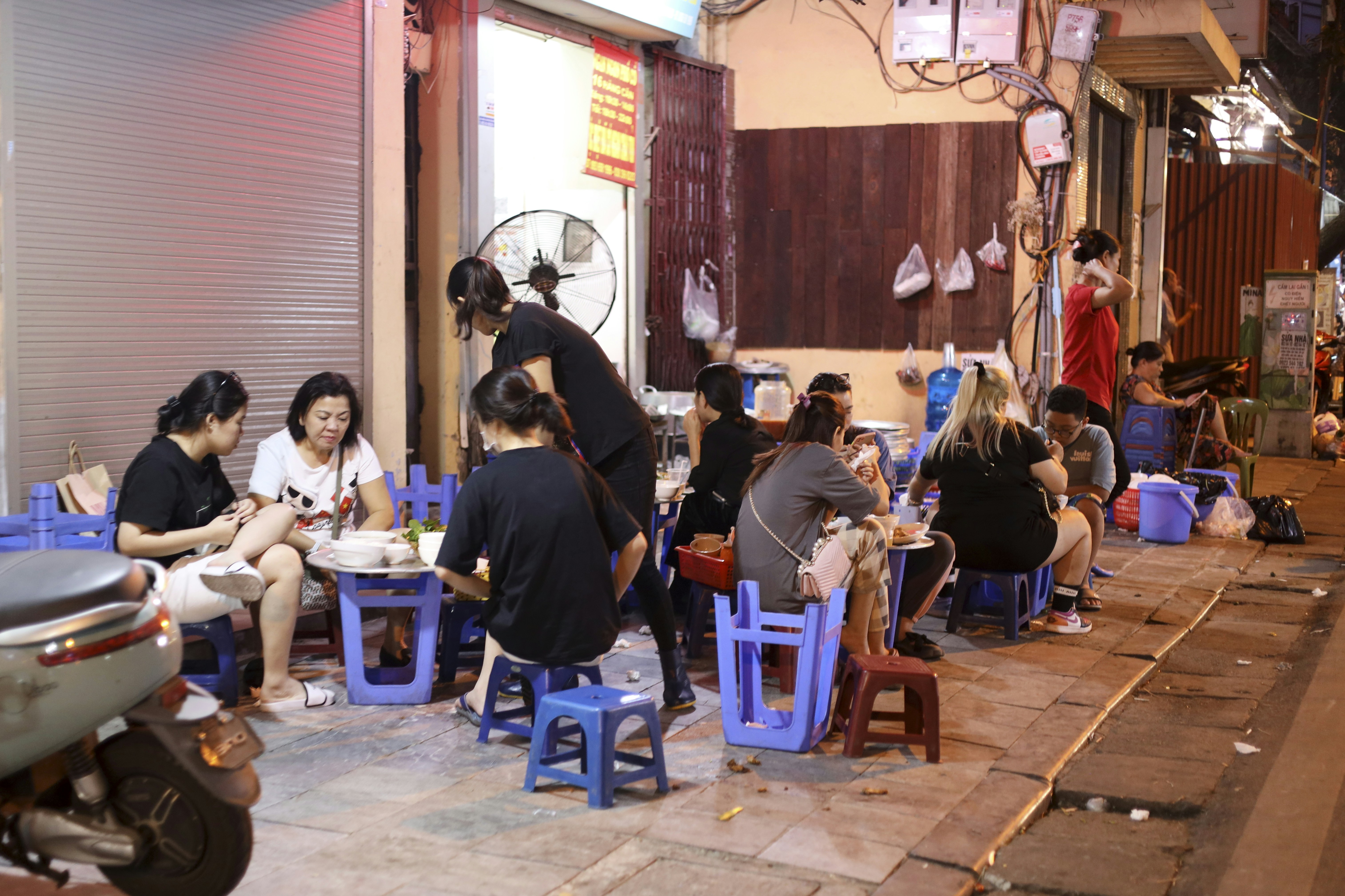 a group of people sitting around a blue table, 