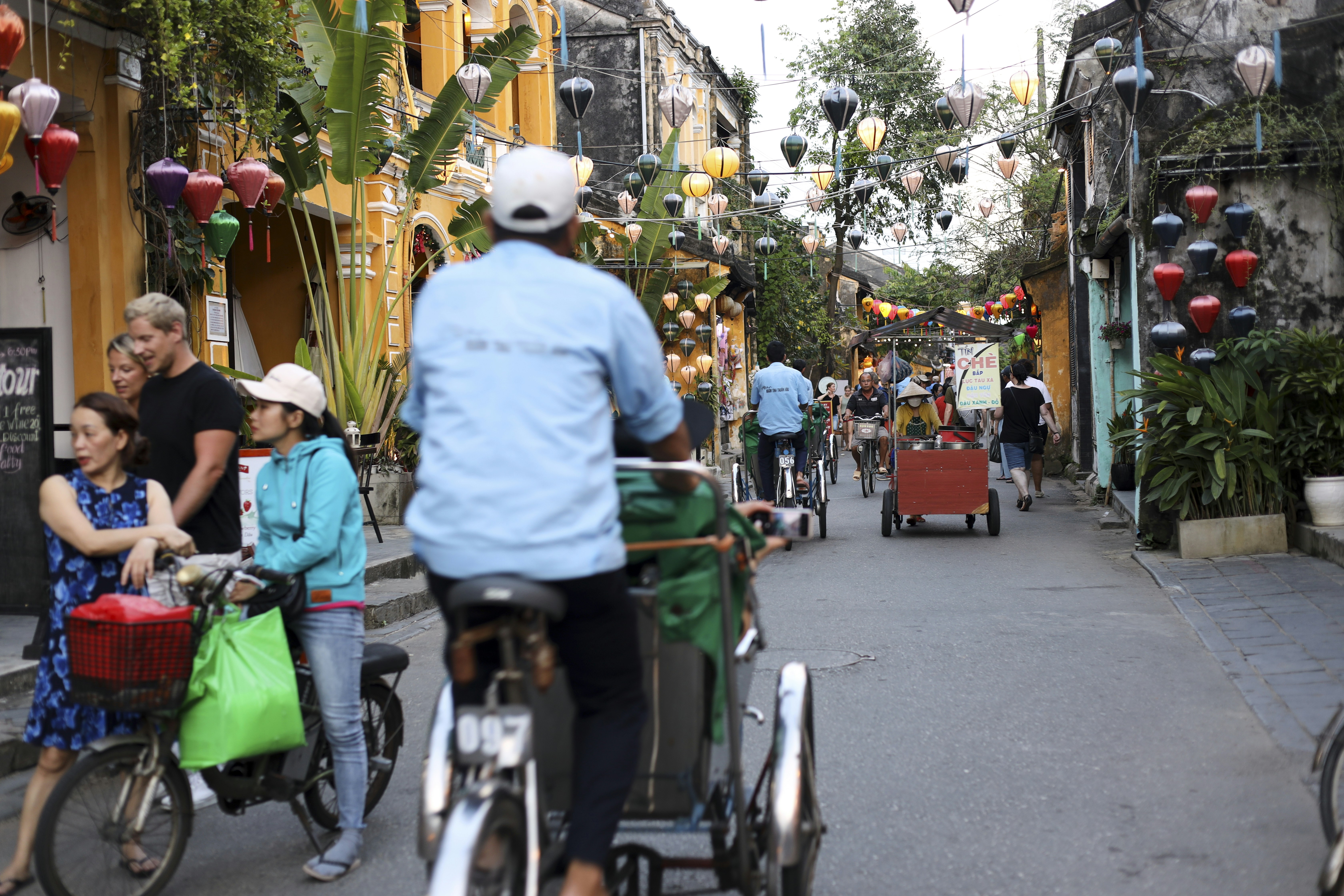 a group of people riding bikes down a street, 