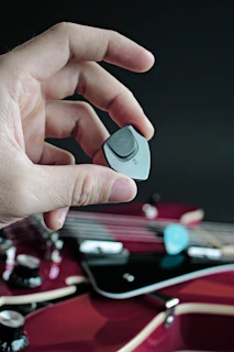 Hands polishing a guitar pick, highlighting the craftsmanship and attention to detail