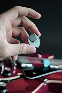Hands polishing a guitar pick, highlighting the craftsmanship and attention to detail