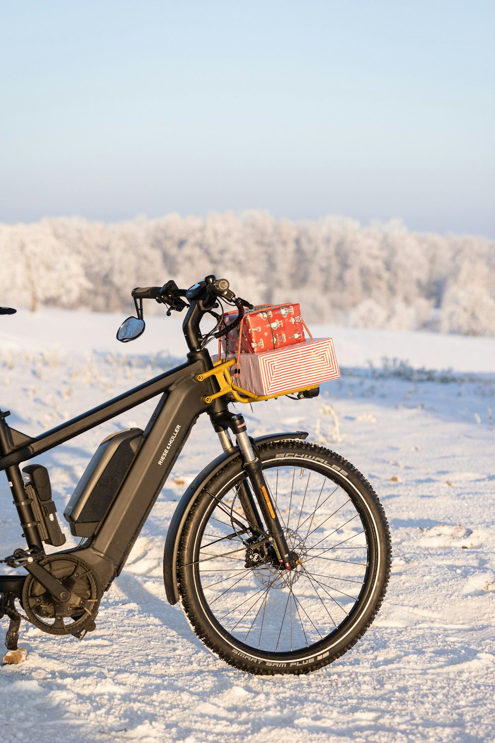 a bicycle parked in the snow with a basket on the back