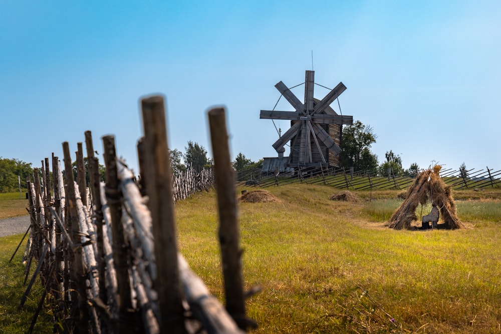 a windmill in the distance behind a fence