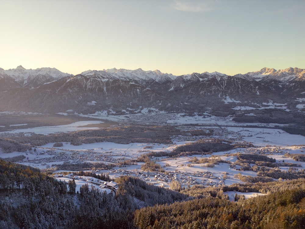 a view of a snowy mountain range with a valley in the foreground