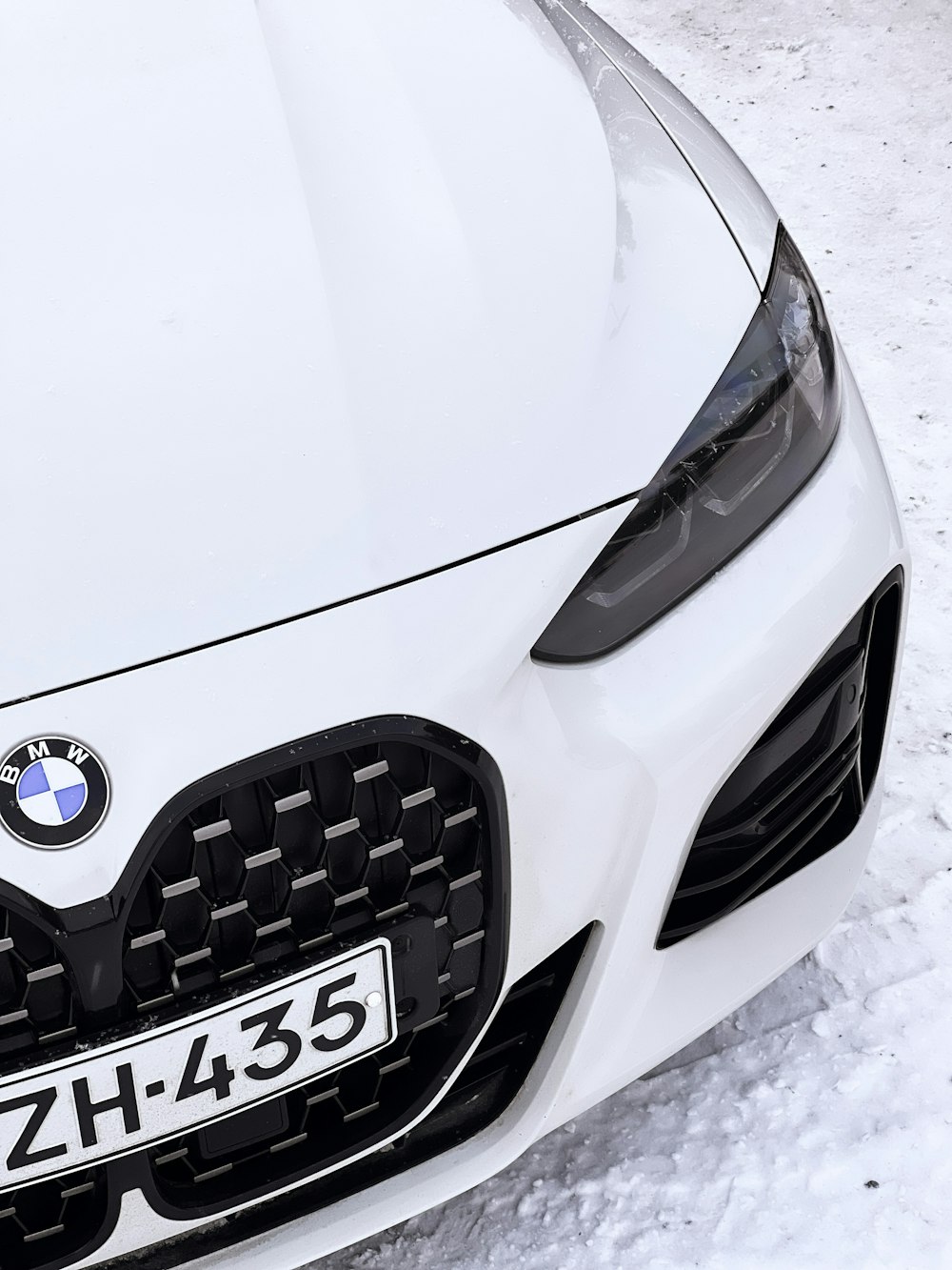 a close up of a white car in the snow