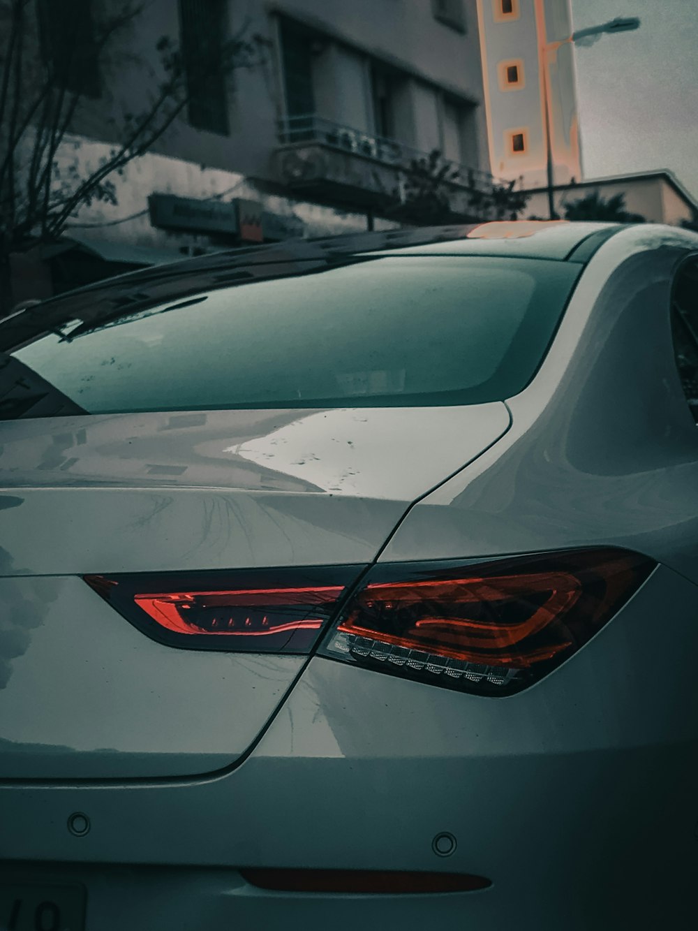 a white car parked in front of a tall building