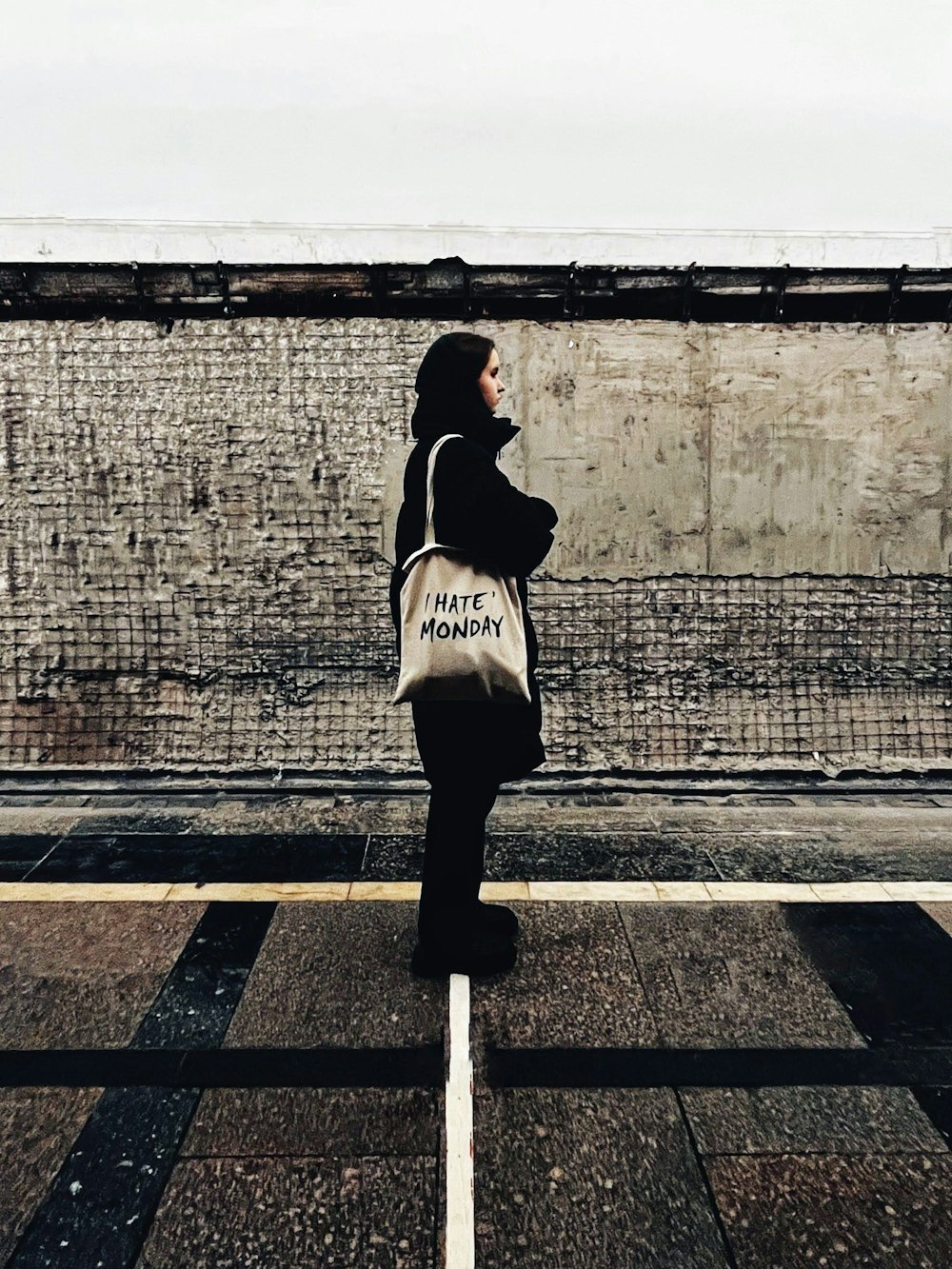 Una mujer parada en una calle sosteniendo una bolsa