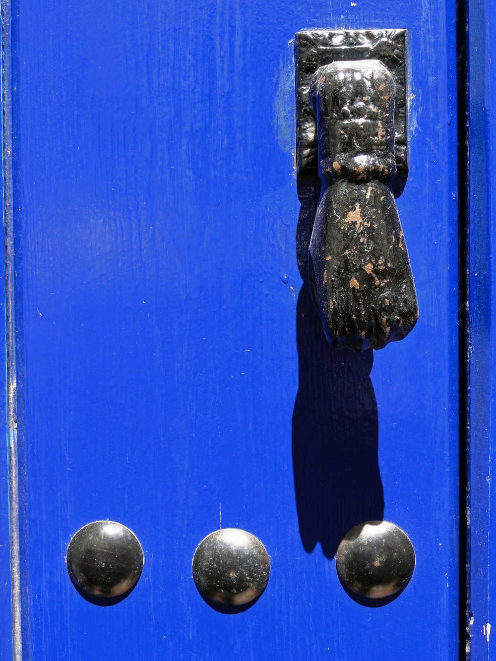 a close up of a blue door with metal knobs