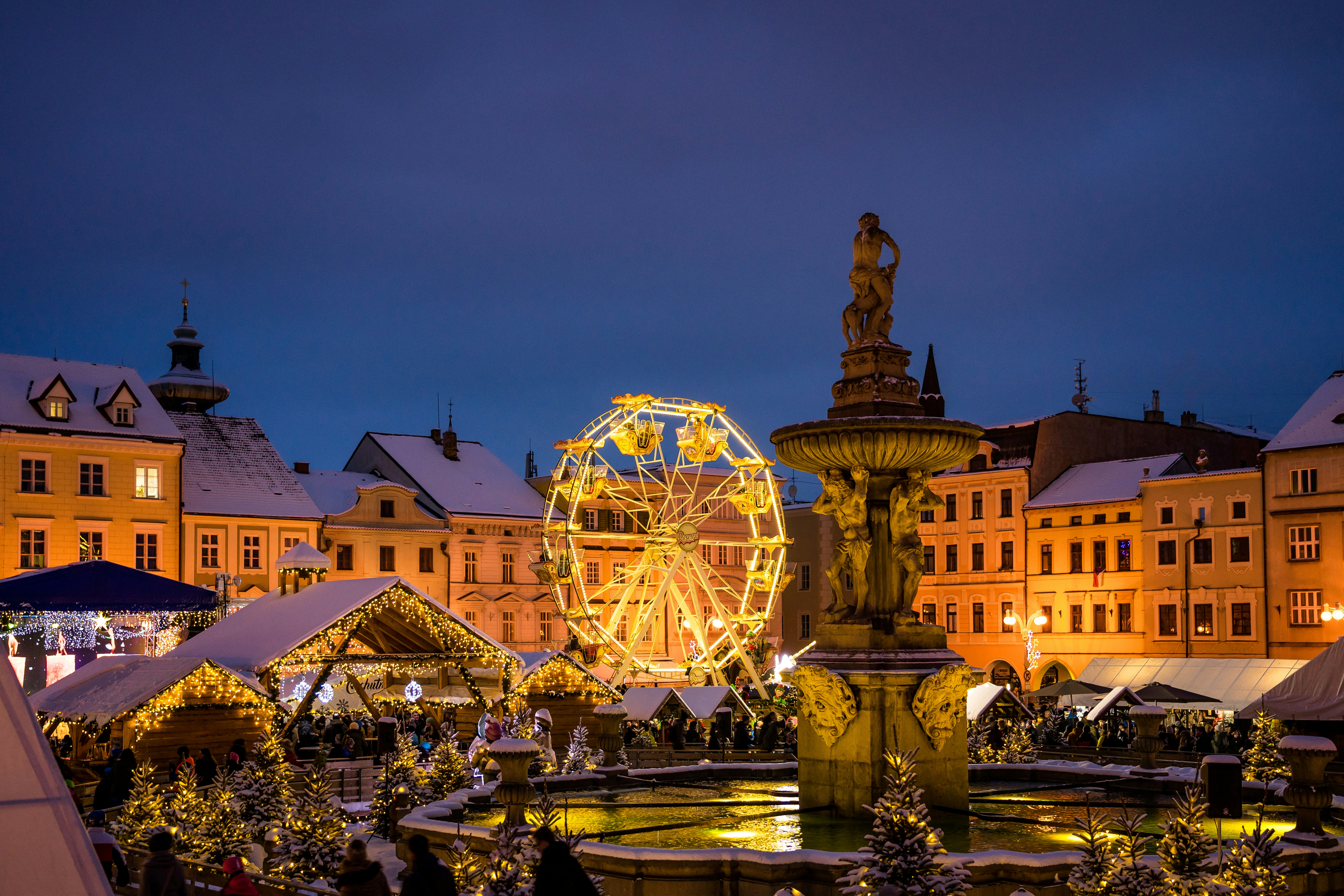 a christmas market with a ferris wheel in the background