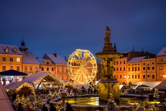 a christmas market with a ferris wheel in the background