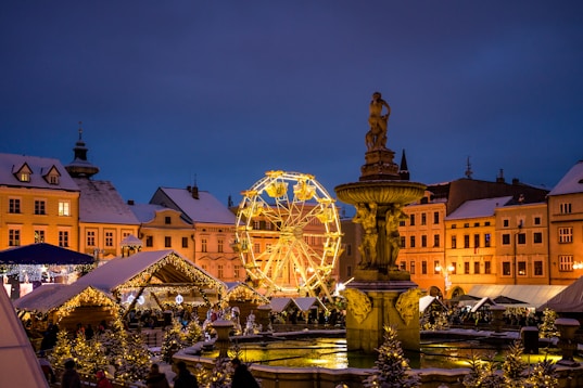 a christmas market with a ferris wheel in the background