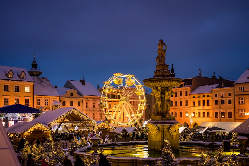 a christmas market with a ferris wheel in the background