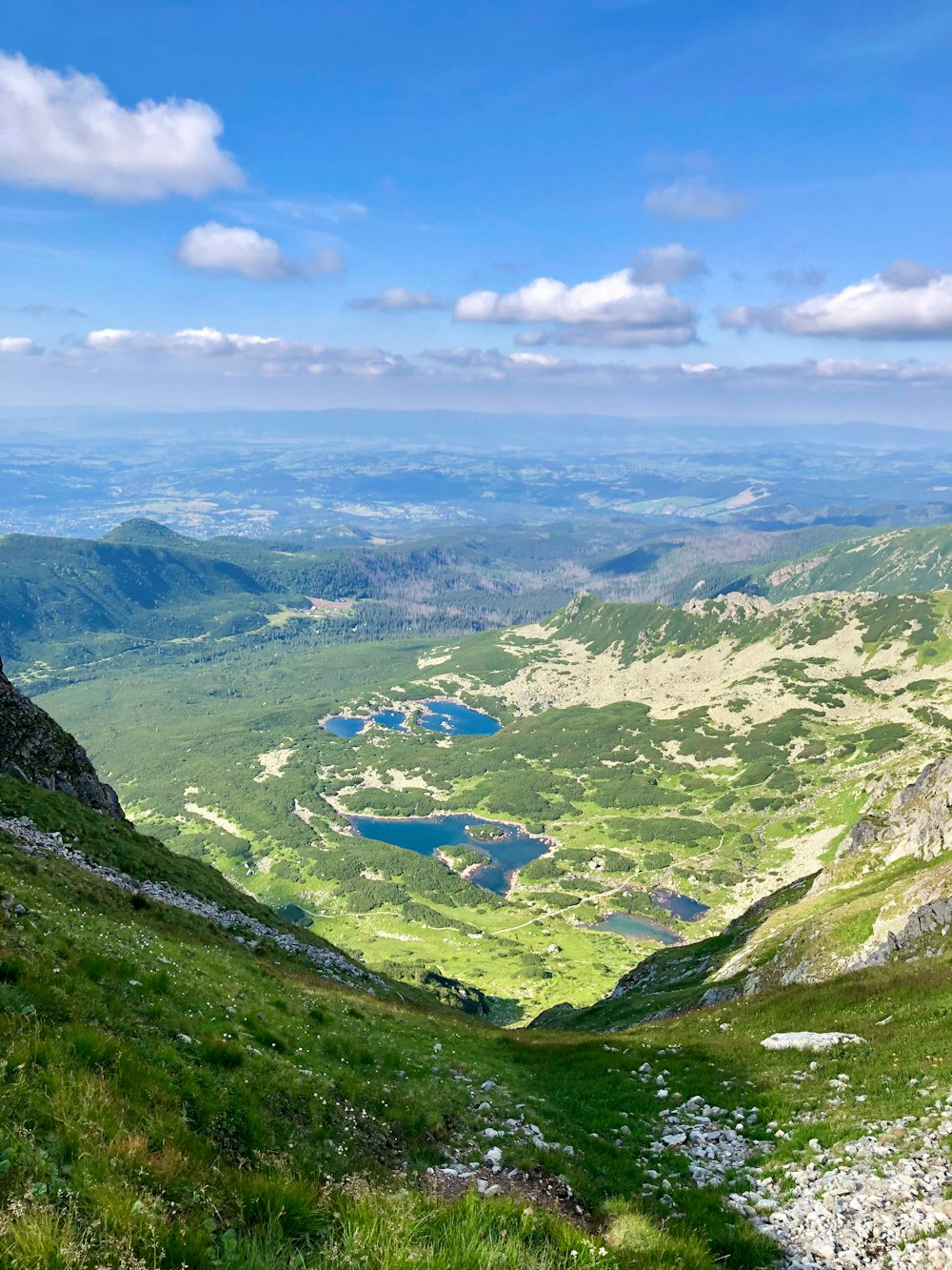 a view of a valley and a lake from the top of a mountain