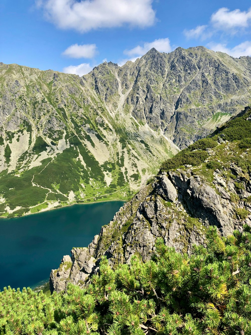 a view of a mountain lake from the top of a hill