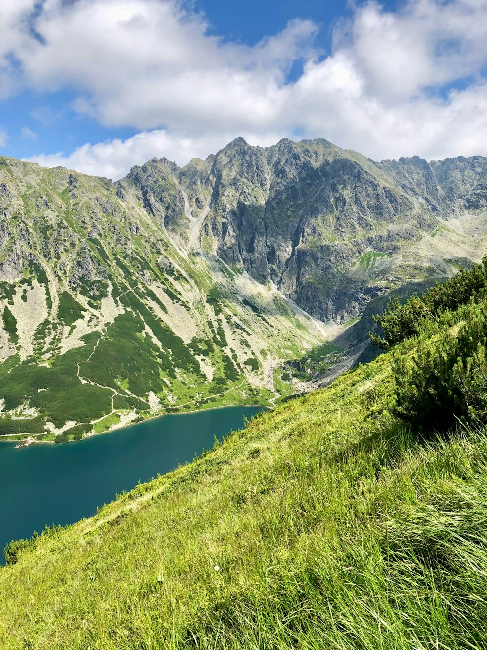 a grassy hill with a lake in the middle of it