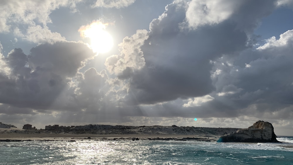 the sun is shining through the clouds over the ocean