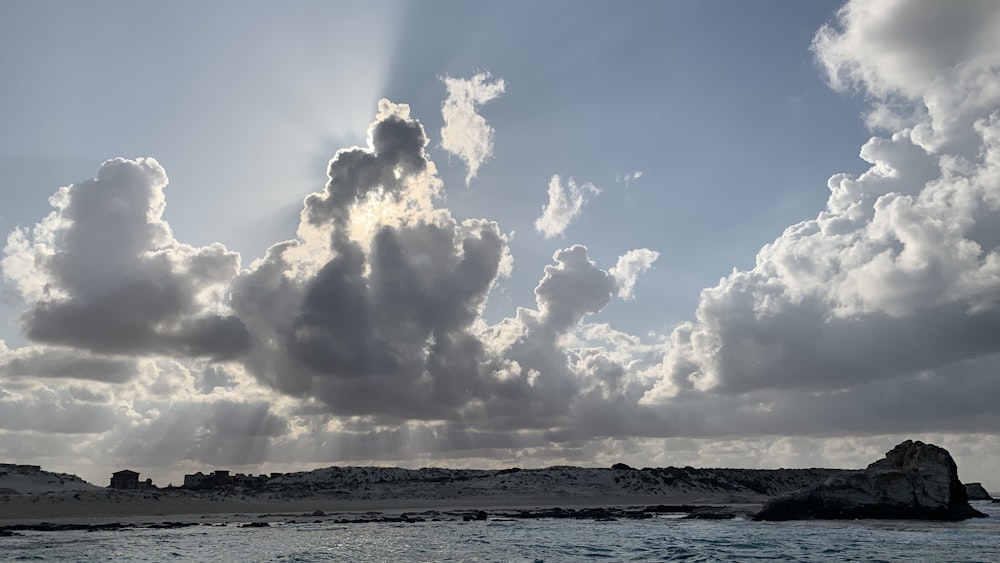 the sun is shining through the clouds over the ocean