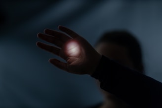 a person holding their hand out in the dark