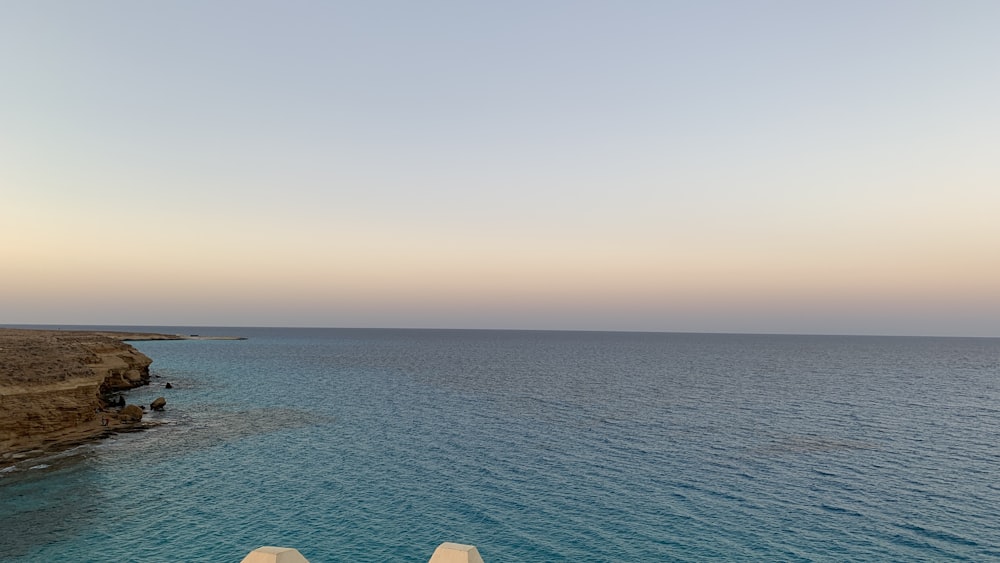 a couple of white chairs sitting on top of a beach